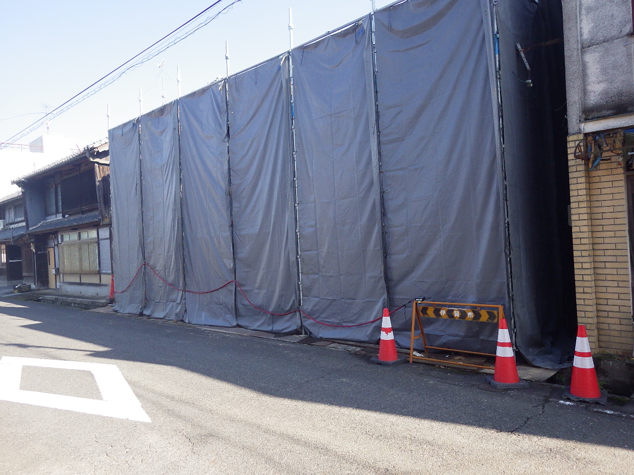 伊賀市の解体業者による丁寧な養生シート設置の様子。粉塵飛散防止と防音対策を徹底した現場管理。